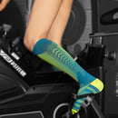 Media deportiva de compresión unisex azul y verde neón en uso para ciclismo, nivel 20-30 mmHg, soporte graduado